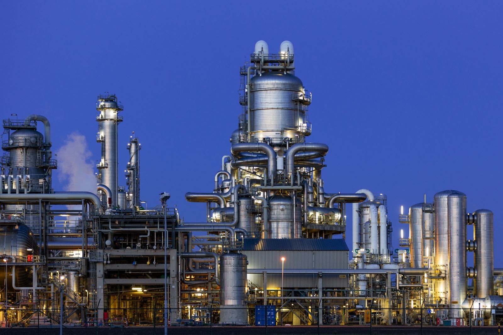 Petrochemical plant illuminated at twilight — the kind of process unit where field instrumentation loops live.